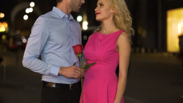 Courteous man gifting rose to his girlfriend whispering compliments in her ear — Stock Video