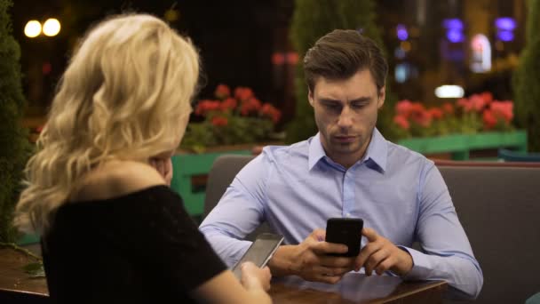 Casal casal não prestando atenção uns aos outros rolando páginas em smartphones — Vídeo de Stock