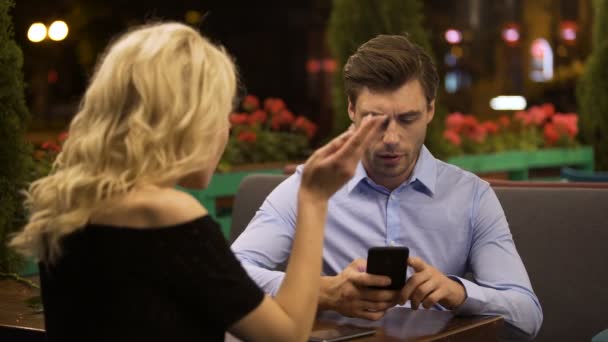 Vrouw probeert aandacht te trekken van haar vriendje die actief bezig met telefoon — Stockvideo