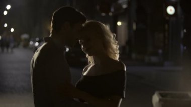 Sarışın kadın alay ve gece sokak, siluetleri erkek sarılma