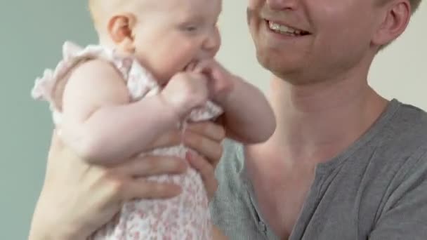 Молодой отец ослепляет маленького ребенка вверх и вниз, счастливое воспитание, отцовская любовь — стоковое видео