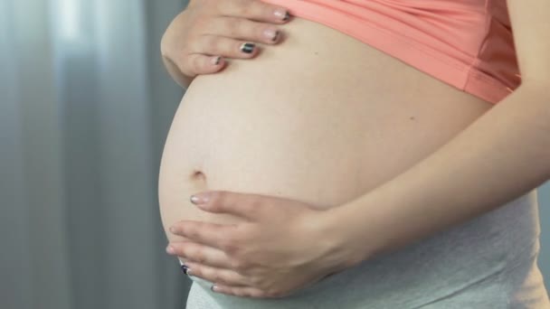 Femme enceinte caressant le ventre en cercles, connexion mère-enfant, attente — Video