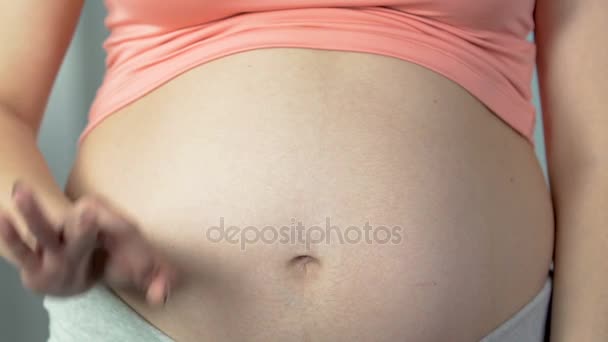Woman pregnant with child showing okay sign and rubbing belly, healthy pregnancy — Stock Video