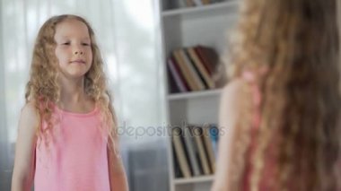 Yetişkin olmak için hayal aynanın önünde, coquetting küçük Kızıl saçlı kız