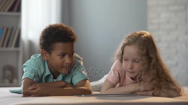Afroamerikanischer Junge schaut hübsches Mädchen aus dem Kindergarten während der Show an — Stockvideo