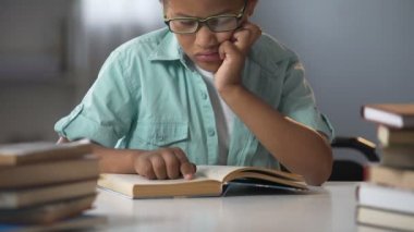 Kütüphane okuma kitapları, eğitim edebiyat oturan gözlüklü akıllı çocuk