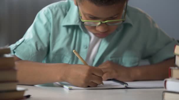 Basisschool leerling ijverig schrijven van brieven in zijn notitieblok, kalligrafie — Stockvideo