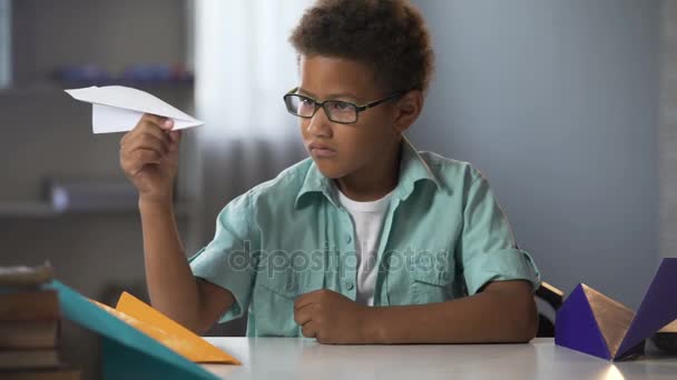 Niño afroamericano aprendiendo a hacer aviones de papel, futuro ingeniero diseñador — Vídeos de Stock