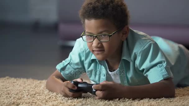 Afro-americano menino absorbedly jogar no novo console de videogame, atividade — Vídeo de Stock