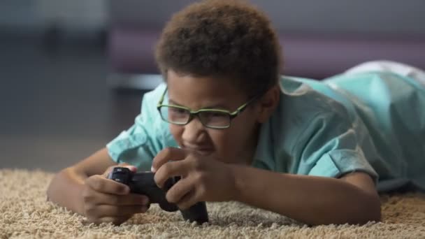 Niño emocionalmente estresado jugando juego activo en la consola, daño a la salud — Vídeos de Stock