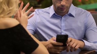 Genç adam cep telefonuyla, ona kayıtsız tutum konuşmak çalışan bir kadına