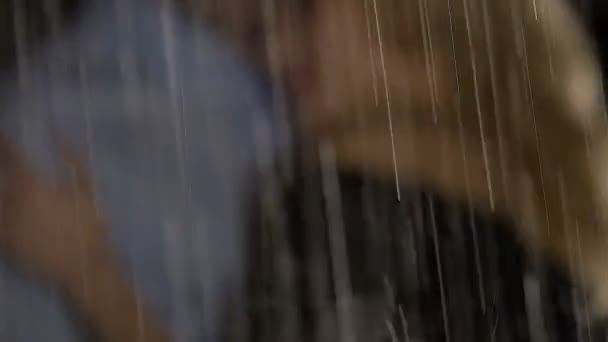 Dešťové kapky silně stéká, mladý muž a žena objímala za datum v dešti