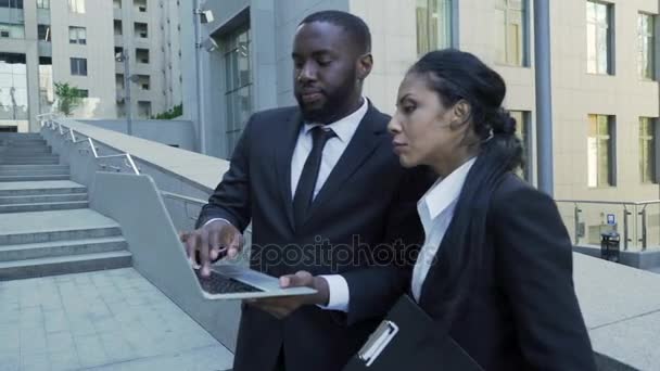 남자와 여 자가 건물, 변호사, 새로운 증거 밖에 서 노트북을 보고 — 비디오