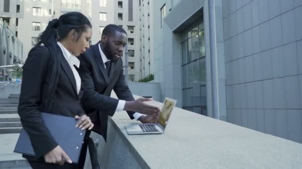 Бизнесмены, стоящие на улице с ноутбуком, беседующие, подготовка переговоров — стоковое видео
