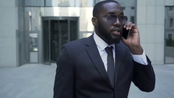 Uzak giriş, yürüyüş takım elbiseli adam telefonda konuşmayı kariyerist — Stok video