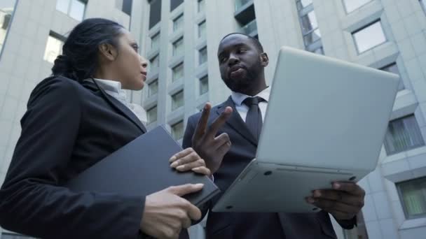 Afroamerikanischer Geschäftsmann hält Laptop in der Hand, gibt Anweisungen an Assistenten, ceo — Stockvideo