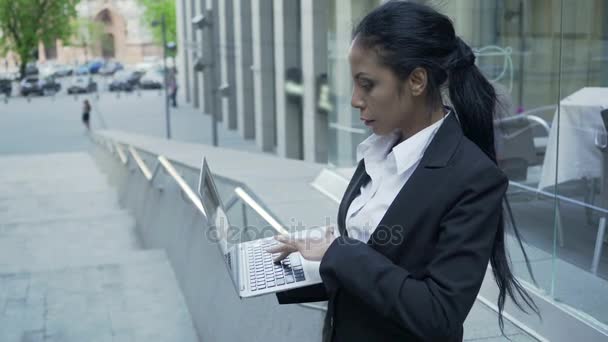 비즈니스 센터 밖에 서 노트북으로 작업 하는 혼혈 사업가 모임 — 비디오