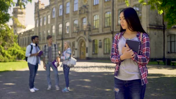 Eenzame biracial meisje staan, boos over spot en grappen van klasgenoten — Stockvideo