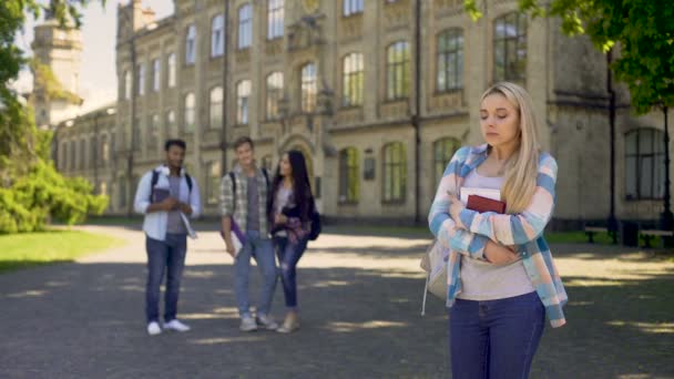 Group of multiracial fellows mocking humble newcomer girl at university — Stock Video