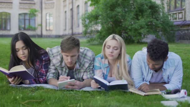 Grupo de estudiantes que participan en el desarrollo personal, acostados en el jardín universitario — Vídeos de Stock