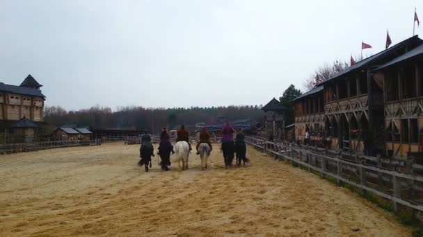 Hommes équitation dans une ligne à travers l'arène sablonneuse, reconstitution de l'âge médiéval — Video