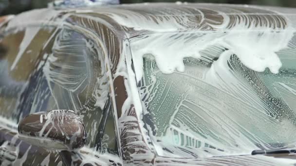 Dure auto bedekt met zeep vlekken, mannelijke wassen auto met spons, service — Stockvideo