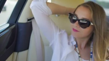 Güzel kadın, lüks araba arkasında oturmak pencere, saç rüzgarda bakarak