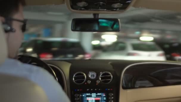 Man driving posh car in underground parking, luxury hotel driver, occupation — Stock Video