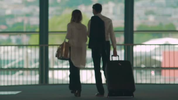 Man and woman stepping on escalator to ride down, guy carrying suitcase, service — Stock Video