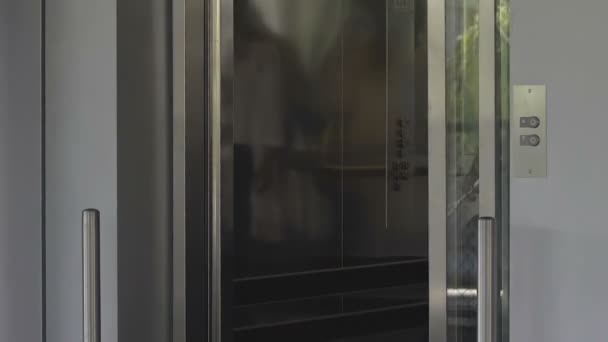 Elevator doors opening, man and female exiting on top floor of luxury hotel — Stock Video