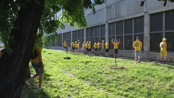 Huligani necultivați aliniindu-se și urinând sub peretele clădirii abandonate — Videoclip de stoc