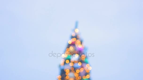 Множество людей ходят по центральной ярко сверкающей рождественской елке накануне — стоковое видео