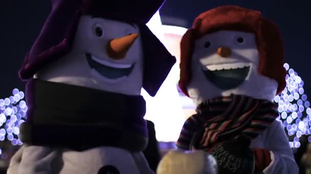 Grappige sneeuwmannen cutely babbelen met voorbijgangers juichen hen omhoog, Kerstmis — Stockvideo