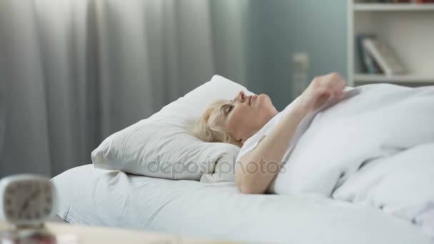 Gesunder Schlaf. Blonde Seniorin schläft im Bett auf orthopädischer Matratze — Stockvideo