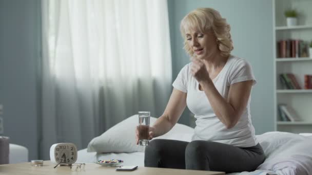 Tevreden middelbare leeftijd vrouw nemen van vitaminen en drinkbaar water, gezondheidszorg — Stockvideo