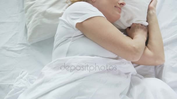 Mujer de mediana edad durmiendo en la cama por la mañana, vista superior de las manos, relajarse — Vídeos de Stock