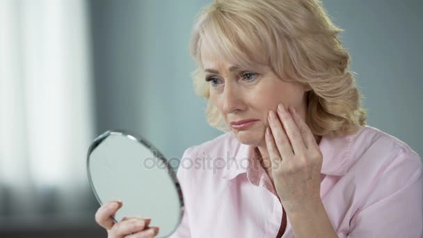 Mujer triste mirando el reflejo de la cara y llorando, infeliz con la piel arrugada — Vídeos de Stock