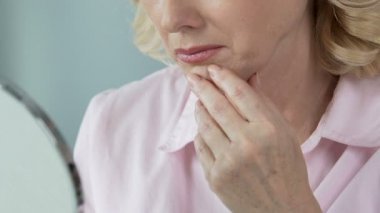 Eski el aynaya bakıyor ve kayıp gençlik, emeklilik için pişman kadın