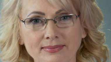 Gülümseyen ve kameraya bakarak profesyonel kadın göz doktoruna yakın çekim