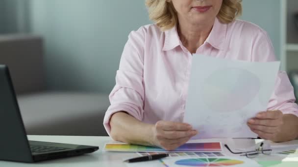 Interior designer choosing color on paper and looking on laptop screen, close-up — Stock Video