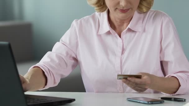 Número de tarjeta de inserción femenina madura en el ordenador portátil, compras en línea, primer plano — Vídeos de Stock