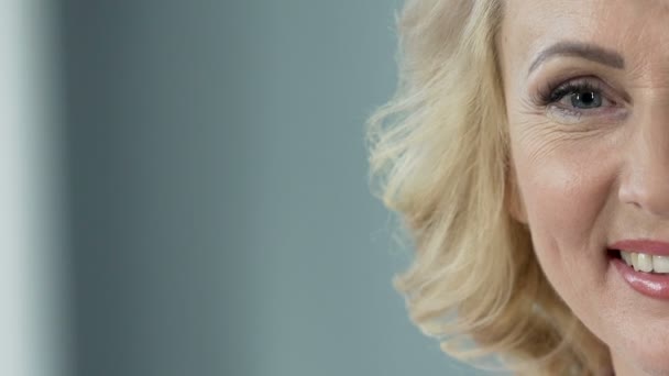Vrolijke senior blonde glimlachend in de camera, plastische chirurgie kliniek, close-up — Stockvideo