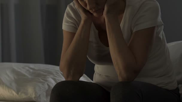 Depressive ältere Dame sitzt auf dem Bett und leidet unter Kopfschmerzen, Gesundheitsproblem — Stockvideo