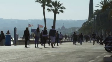 Nice, Fransa - Haziran 2016 yaklaşık. Şehirde turist. Bir grup insan mesire, yürüyüş Rüzgar bayrakları içinde çırpınan seyir