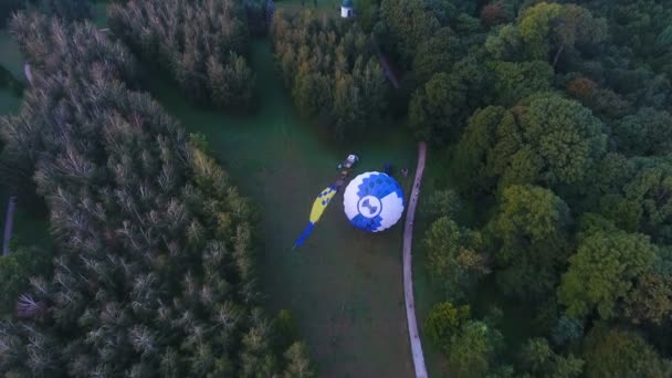 Пилоты поднимают конверт с воздушным шаром, корзина на земле, подготовка — стоковое видео