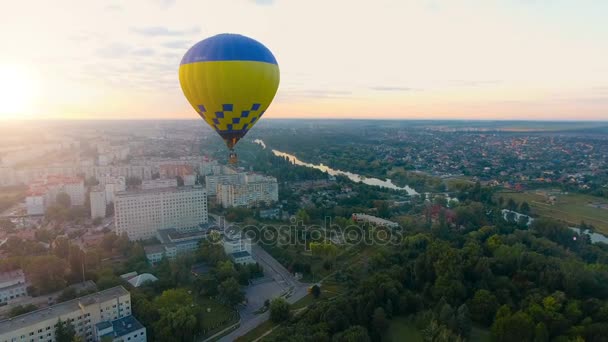 Vários balões de ar quente flutuando sobre a cidade em direção ao sol nascente ao longo do horizonte, esperança — Vídeo de Stock