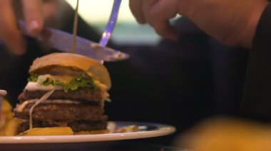 Burger parça kesme ve fast food ve obezite, yakın çekim yemek adam