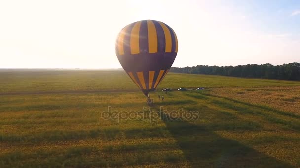 Människor gå runt korg av luftballong landade i fältet destination — Stockvideo