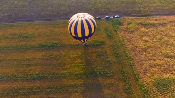 Mand van hete lucht ballon staande op veld, mensen springen van de gondel, voltooien — Stockvideo