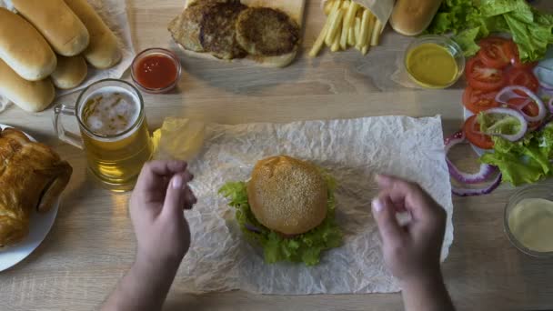 Cara removendo costeleta gordurosa de hambúrguer, mantendo a dieta saudável, perder peso — Vídeo de Stock